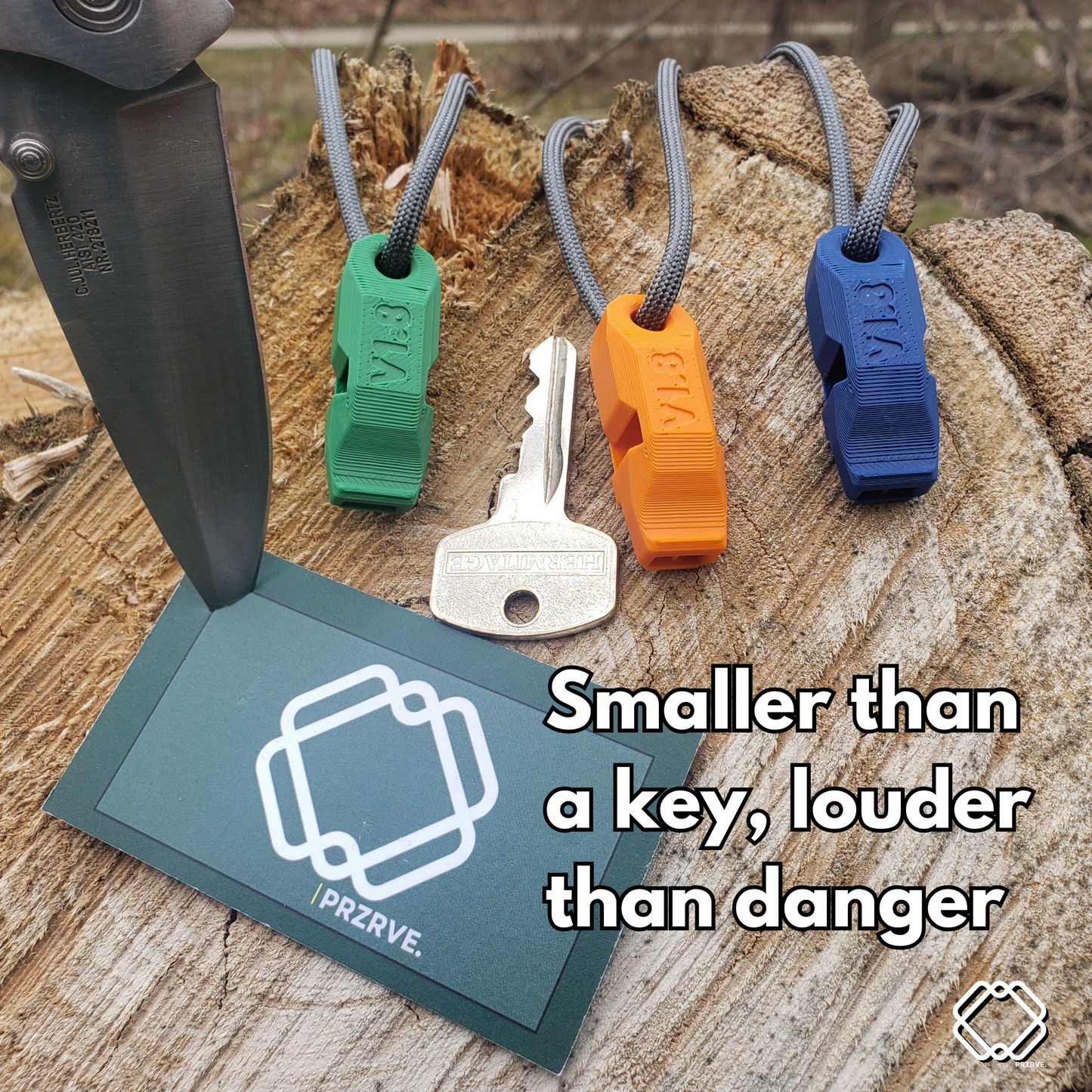 Three colorful whistles on a wooden surface with a PRZERVE tag and text.
